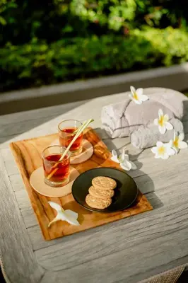 a table with a plate of cookies and glasses of tea at Villa Dewata One in Seminyak