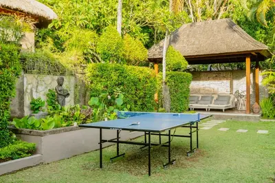 a ping pong table in a garden with a gazebo at Villa Dewata One in Seminyak
