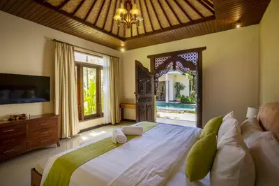 a bedroom with a large bed and a large window at Villa Katara in Seminyak