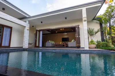 a swimming pool in front of a villa at Villa Katara in Seminyak