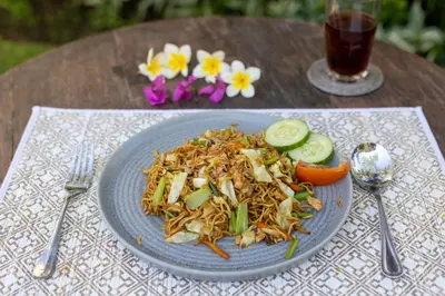 a blue plate of food on a table with a salad at Villa Katara in Seminyak