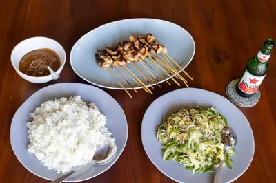 a table with plates of food and bowls of rice at Villa Katara in Seminyak