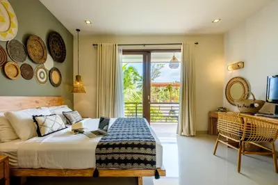 a bedroom with a bed with a table and a window at The Akasha Seminyak Bali Boutique Hotel in Seminyak