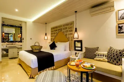 a hotel room with a bed and a couch at The Akasha Seminyak Bali Boutique Hotel in Seminyak
