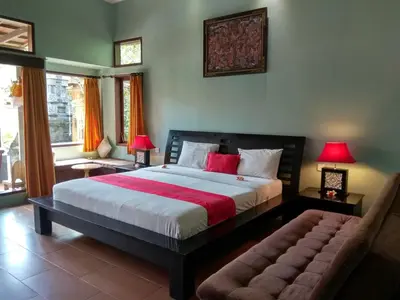a bedroom with a large bed and a couch at D'Kubu Legian in Legian