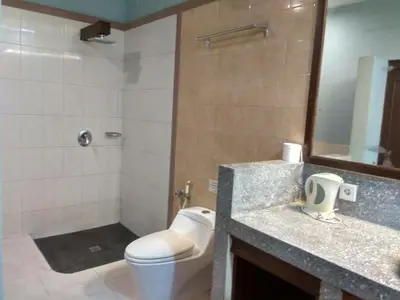a bathroom with a toilet and a sink and a mirror at D'Kubu Legian in Legian