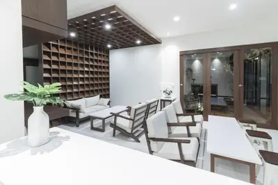 a dining room with white tables and chairs at Kak Garden Inn in Kuta