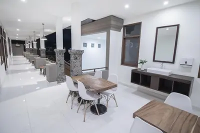 a dining room with a table and chairs at Kak Garden Inn in Kuta