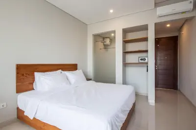 a bedroom with a large bed with white sheets at Eclipse Kerobokan in Kerobokan