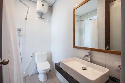 a bathroom with a sink and a toilet and a mirror at Eclipse Kerobokan in Kerobokan