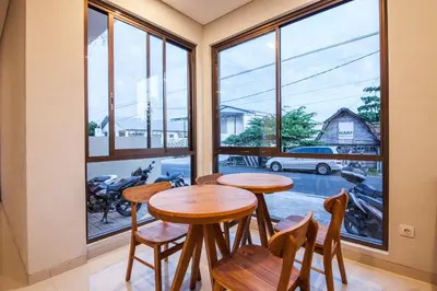 a dining room with two tables and a large window at Eclipse Kerobokan in Kerobokan