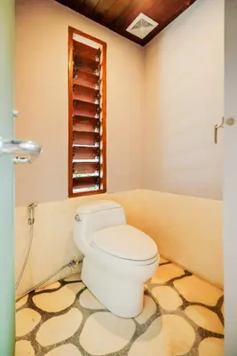 a bathroom with a toilet and a window at Kashantee Village in Seminyak