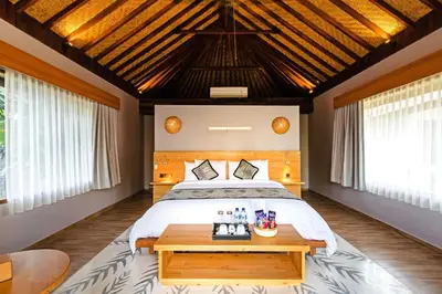 a bedroom with a large bed and a table at Kashantee Village in Seminyak