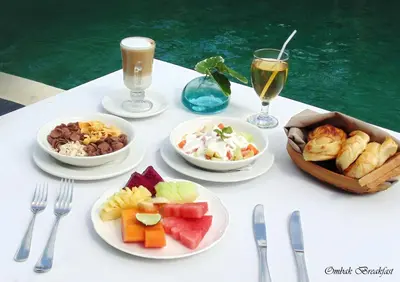 a table with plates of food and glasses of wine at Gending Kedis Luxury Villas & Spa Estate in Jimbaran
