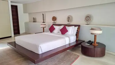 a bedroom with a large white bed with red pillows at The Layar - Designer Villas and Spa in Seminyak