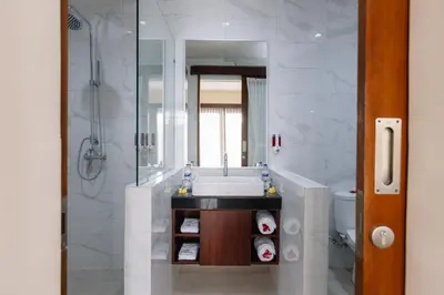 a bathroom with a sink and a shower and a toilet at Kubu Benoa Guest House in Nusa Dua