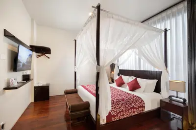 a bedroom with a four poster bed with a canopy at 18 Suite Villa Kuta in Kuta