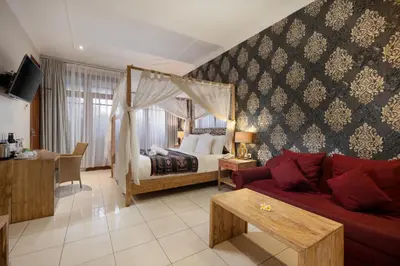 a living room with a bed and a red couch at 18 Suite Villa Kuta in Kuta