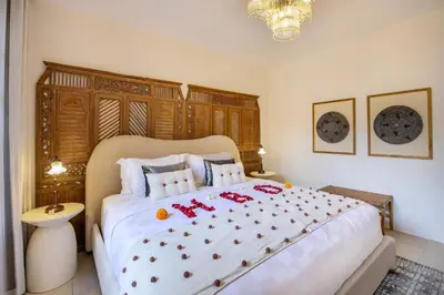 a bedroom with a large white bed with red bows on it at Villa Casa Adeline in Canggu