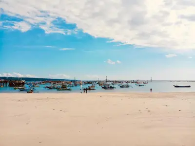 a beach with a bunch of boats in the water at Familytel Bali in Jimbaran