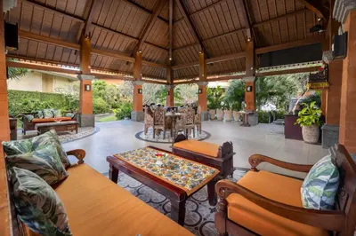 an outdoor living room with a table and chairs at Adi Dharma Hotel Kuta in Kuta