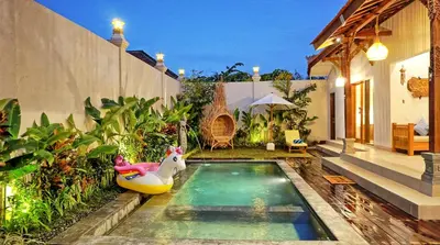 a backyard with a pool with a toy horse in a raft at Sarayu Villa in Seminyak