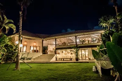 a large white house with a garden at night at La Payesa in Canggu