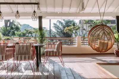 a restaurant with a table and chairs and a large window at La Payesa in Canggu