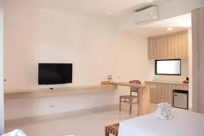 a living room with a table and a tv on the wall at Metta Agara in Kerobokan