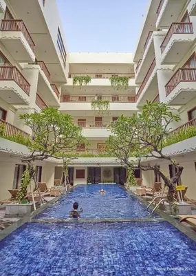 a boy swimming in a large swimming pool in a building at Sense Sunset Hotel Seminyak in Seminyak