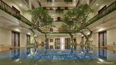 a pool with trees in the middle of a building at Sense Sunset Hotel Seminyak in Seminyak