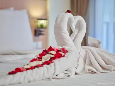 a towel shaped like a swan with hearts on a bed at Sense Sunset Hotel Seminyak in Seminyak