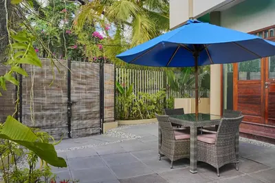 a table and chairs with an umbrella on a patio at Kyara Villa Apartments in Canggu