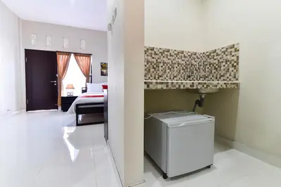 a room with a bathroom with a sink and a room with a bed at RedDoorz Plus near Jalan Imam Bonjol Denpasar in Seminyak
