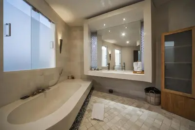 a bathroom with a large tub and a large mirror at Luxury Villa Juno Seminyak in Seminyak