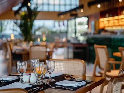 a table in a restaurant with wine glasses on it at Cross Paasha Bali Seminyak in Seminyak
