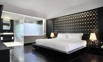 a bedroom with a large white bed and a bathroom at Cross Paasha Bali Seminyak in Seminyak