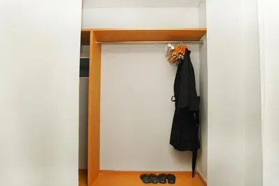 a room with a closet with a black umbrella and shoes at Cross Paasha Bali Seminyak in Seminyak