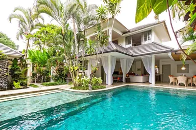 a villa with a swimming pool in front of a house at Villa Eindra Seminyak in Seminyak