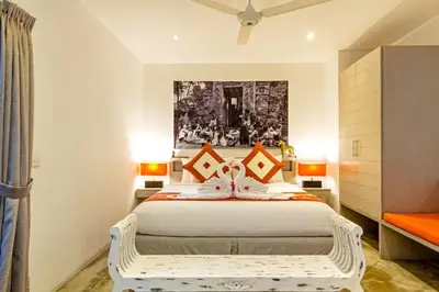 a bedroom with a large white bed with orange pillows at Villa Eindra Seminyak in Seminyak