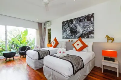 two beds in a room with a large window at Villa Eindra Seminyak in Seminyak