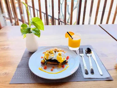 a plate of food on a table with a glass of orange juice at The Salila Beach Resort in Seminyak
