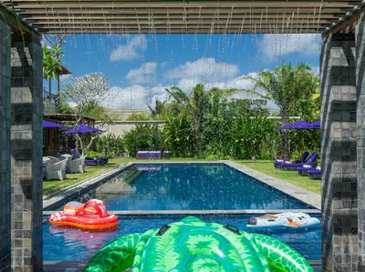a swimming pool with two inflatable boats in the water at Sayang d'Amour in Seminyak