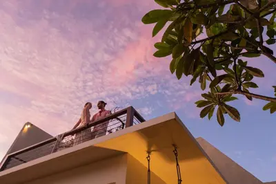 a man and a woman sitting on top of a building at Ayona Villa Seminyak by Ini Vie Hospitality in Seminyak