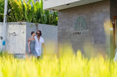 a man and a woman walking in front of a sign at Ayona Villa Seminyak by Ini Vie Hospitality in Seminyak
