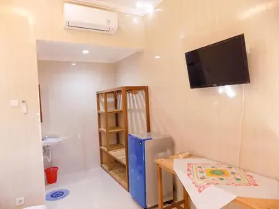 a small room with a tv on the wall at Guna Graha Kuta by Kamara in Kuta