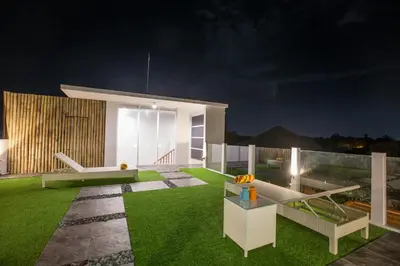 a backyard at night with a couch and grass at Villa Ultima Umalas in Canggu