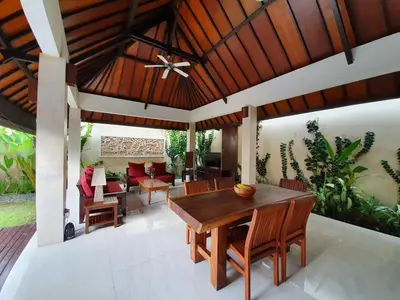 an outdoor dining room with a wooden ceiling at Villa Davenny in Seminyak