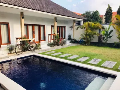 a house with a swimming pool in front of a house at Villa Pintu Biru in Seminyak