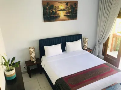 a bedroom with a large bed with white sheets at Villa Pintu Biru in Seminyak